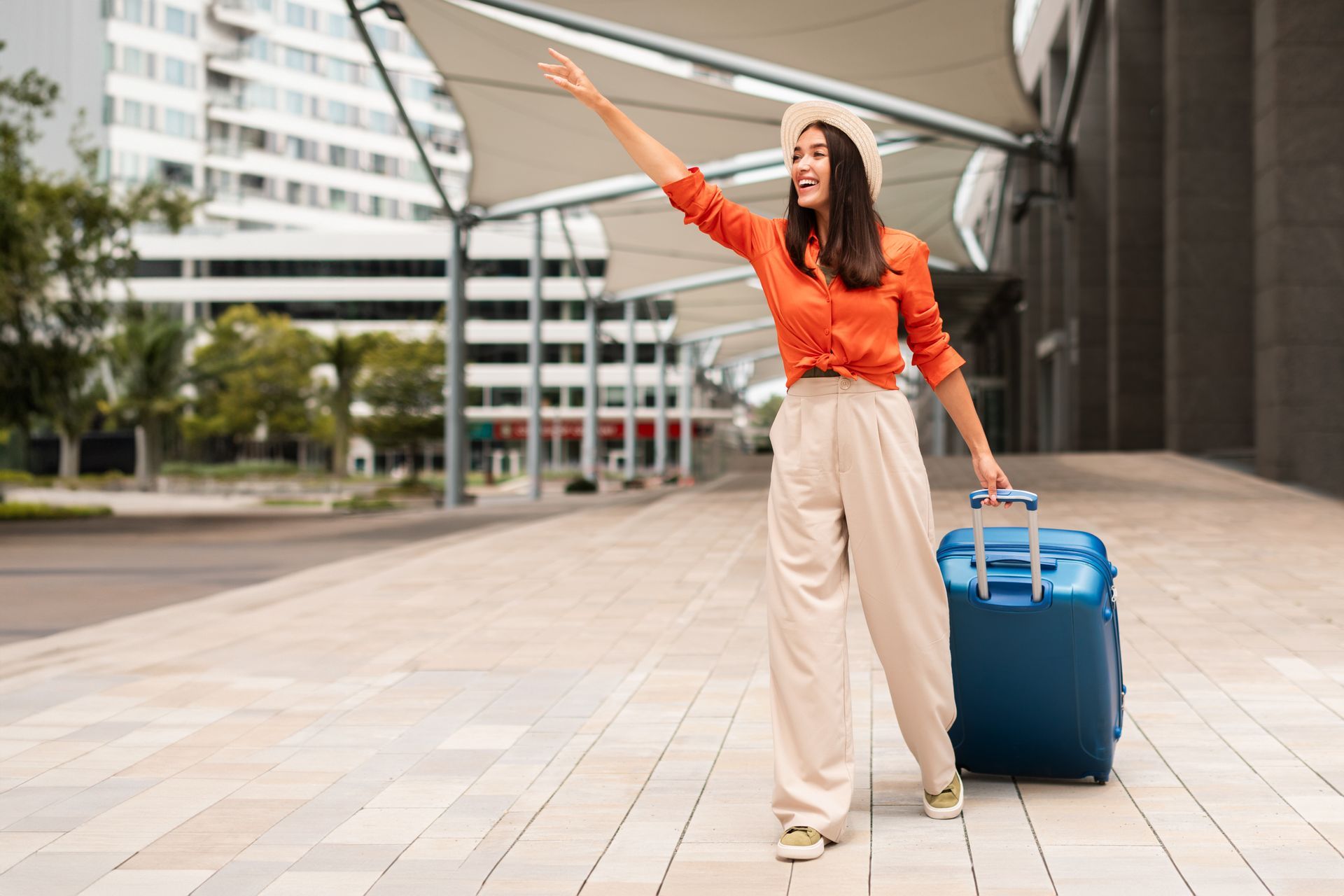 Une femme avec une valise qui appelle un taxi