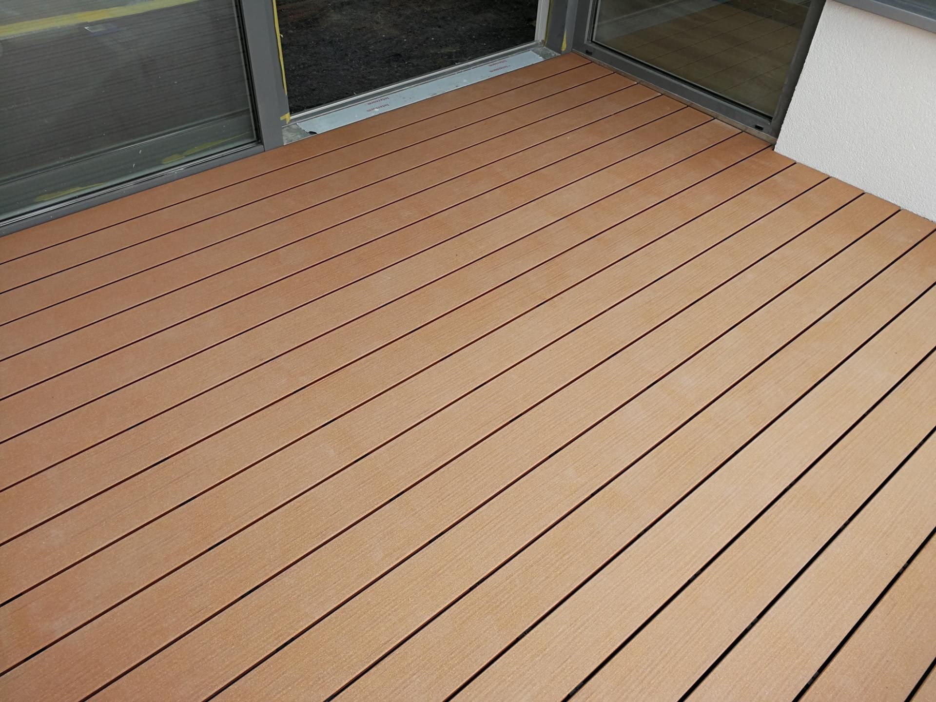 Detailaufnahme eines Holzdecks auf einem Balkon mit Längsrillen für besseren Halt.