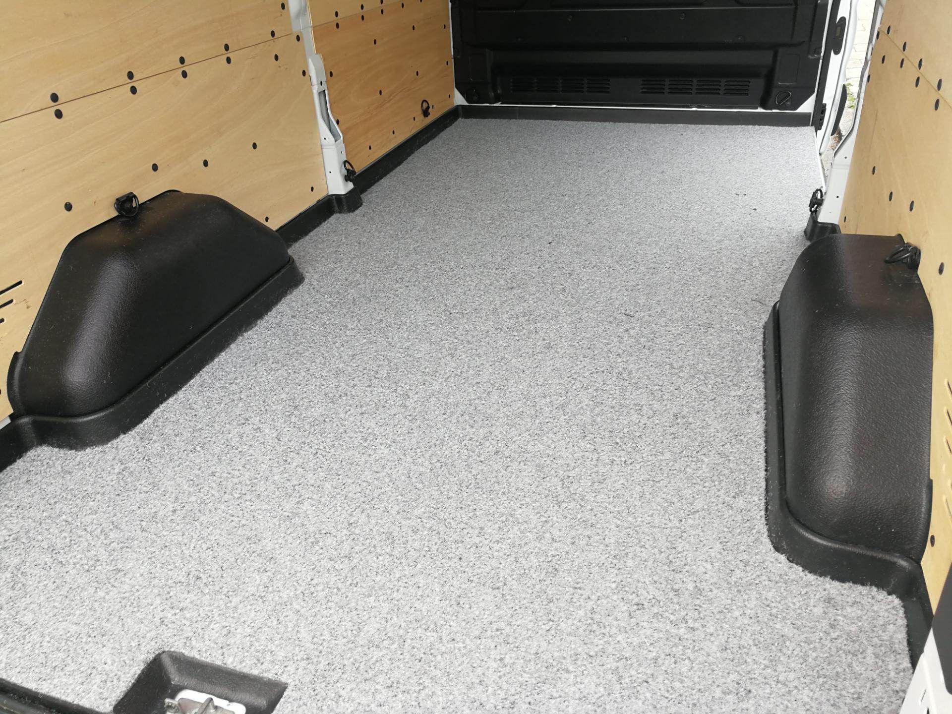 Fahrzeuginnenraum mit strapazierfähigem, hellgrauem Bodenbelag aus Kunststoff.