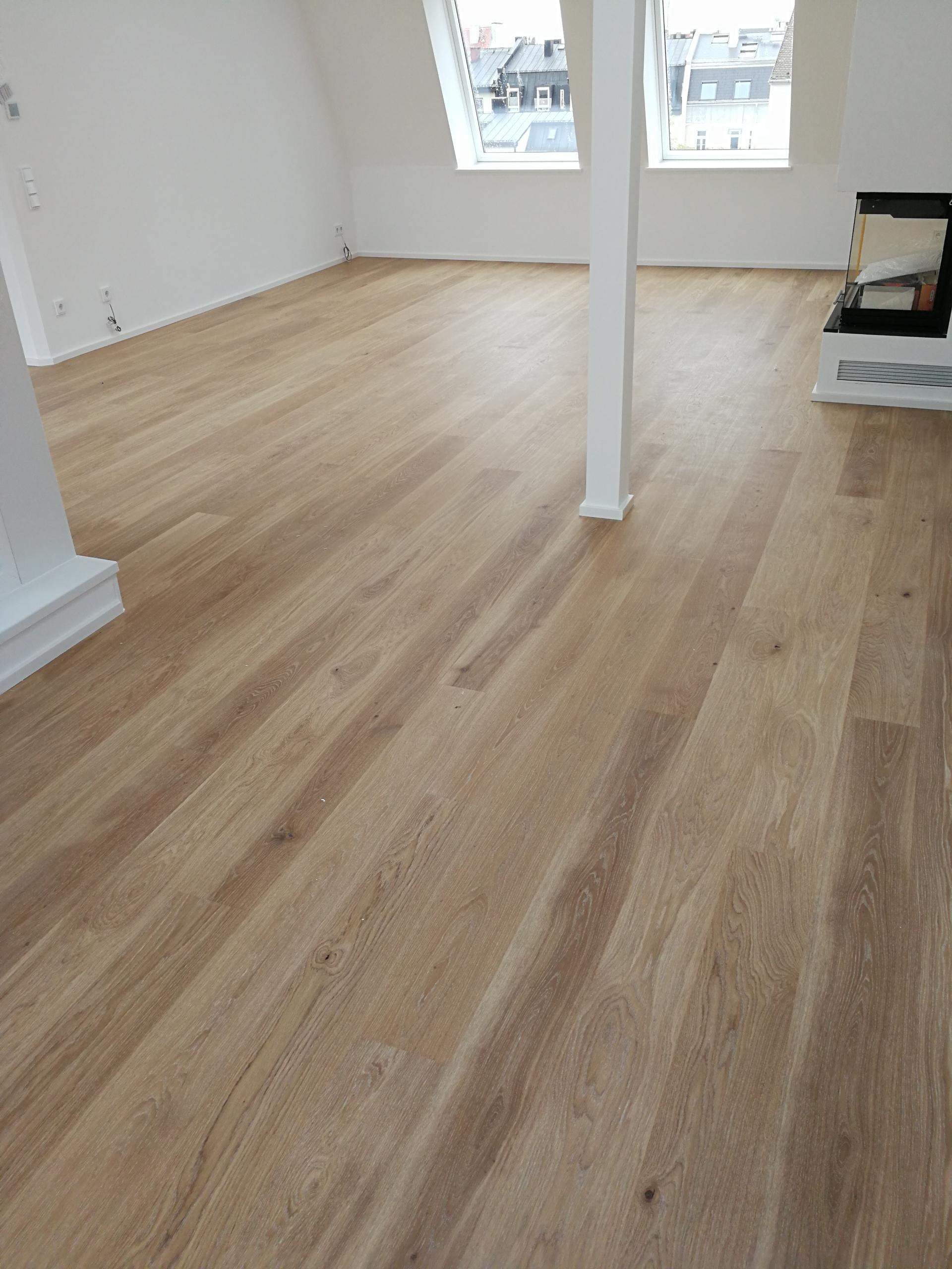 Laminatboden in einem Raum mit weißer Wand und Heizkörper, modern und schlicht.