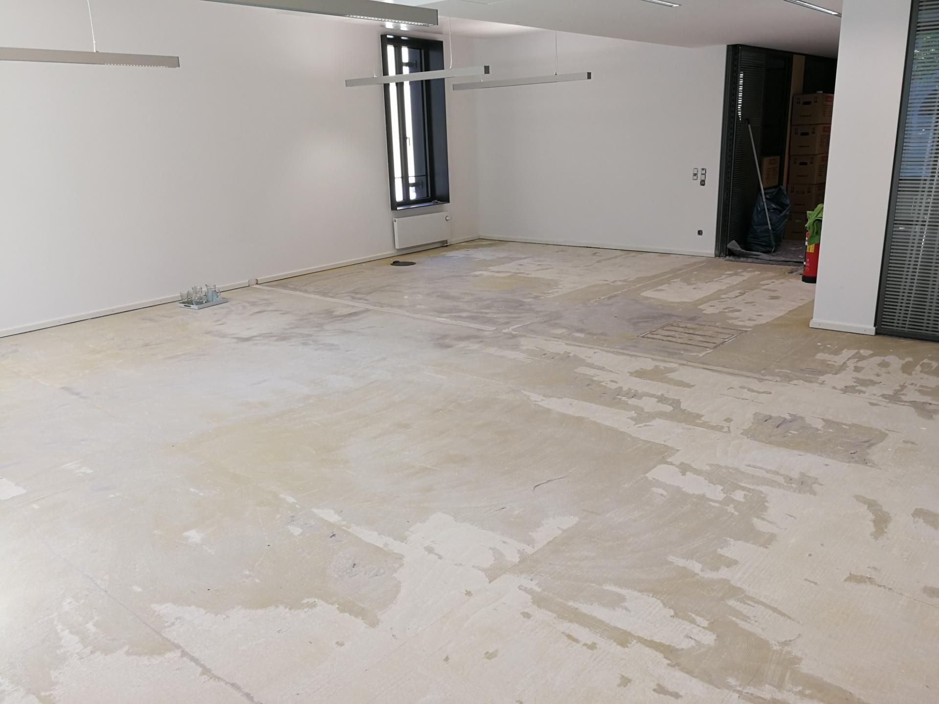 Raum mit entfernten Bodenbelägen, vorbereiteter Untergrund für neue Verlegung.