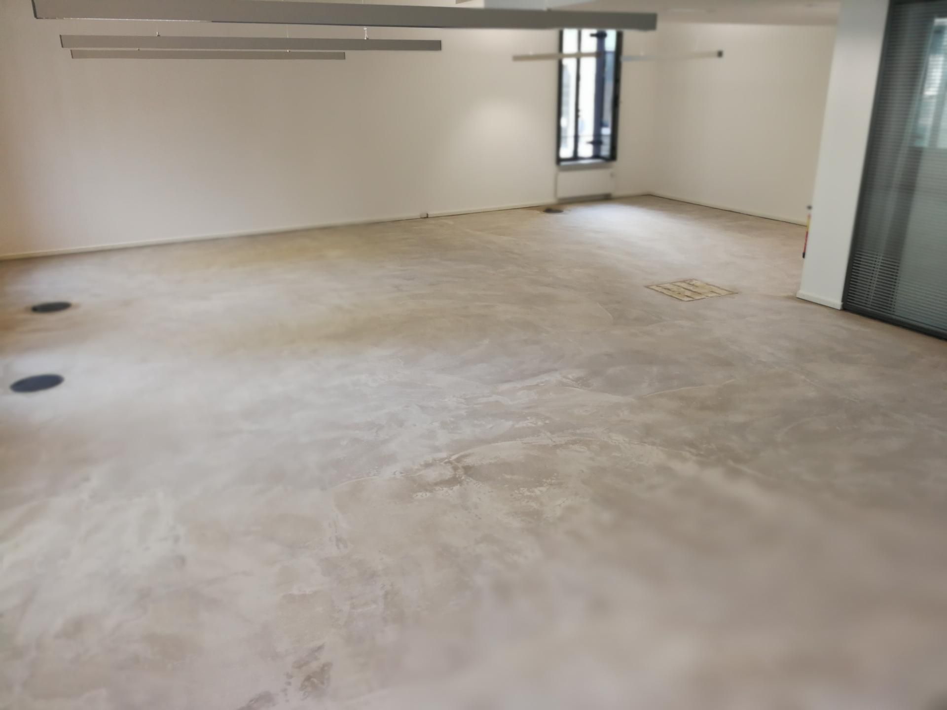 Leerer Raum mit Betonboden, Vorbereitung für Bodenverlegung sichtbar.