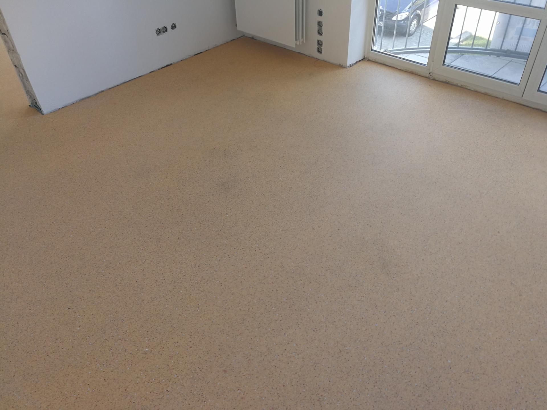 Lichtdurchfluteter Raum mit hellbraunem Korkboden und weißen Wänden.