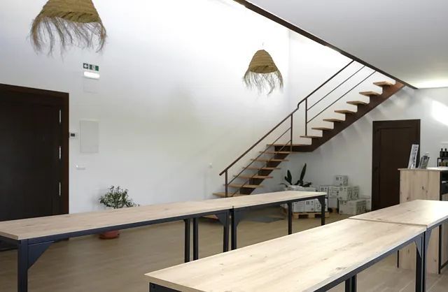 Una habitación con mesas y escaleras.