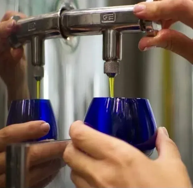 Una persona está vertiendo líquido en un vaso azul.