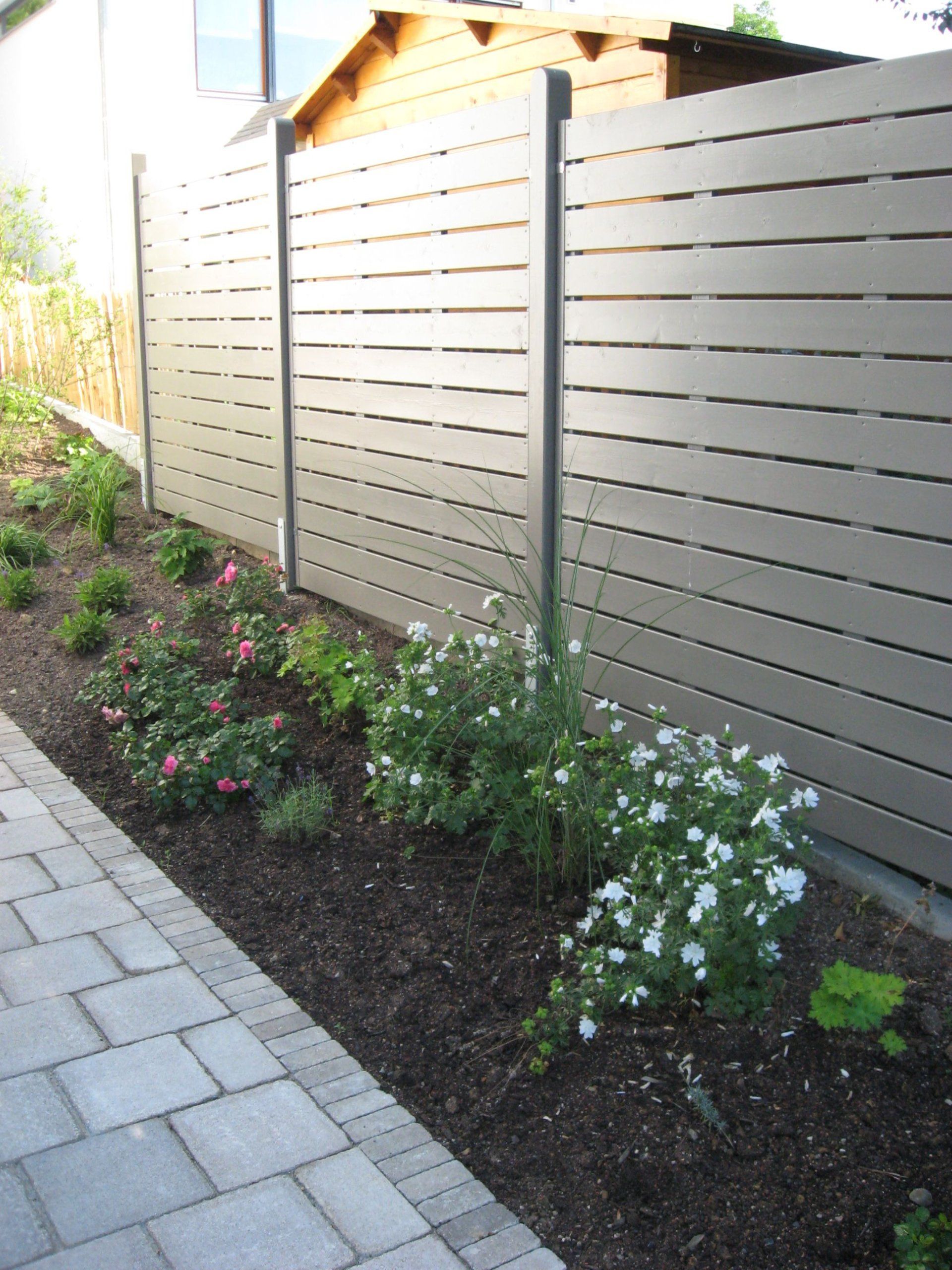 Ein Holzzaun mit Blumen davor