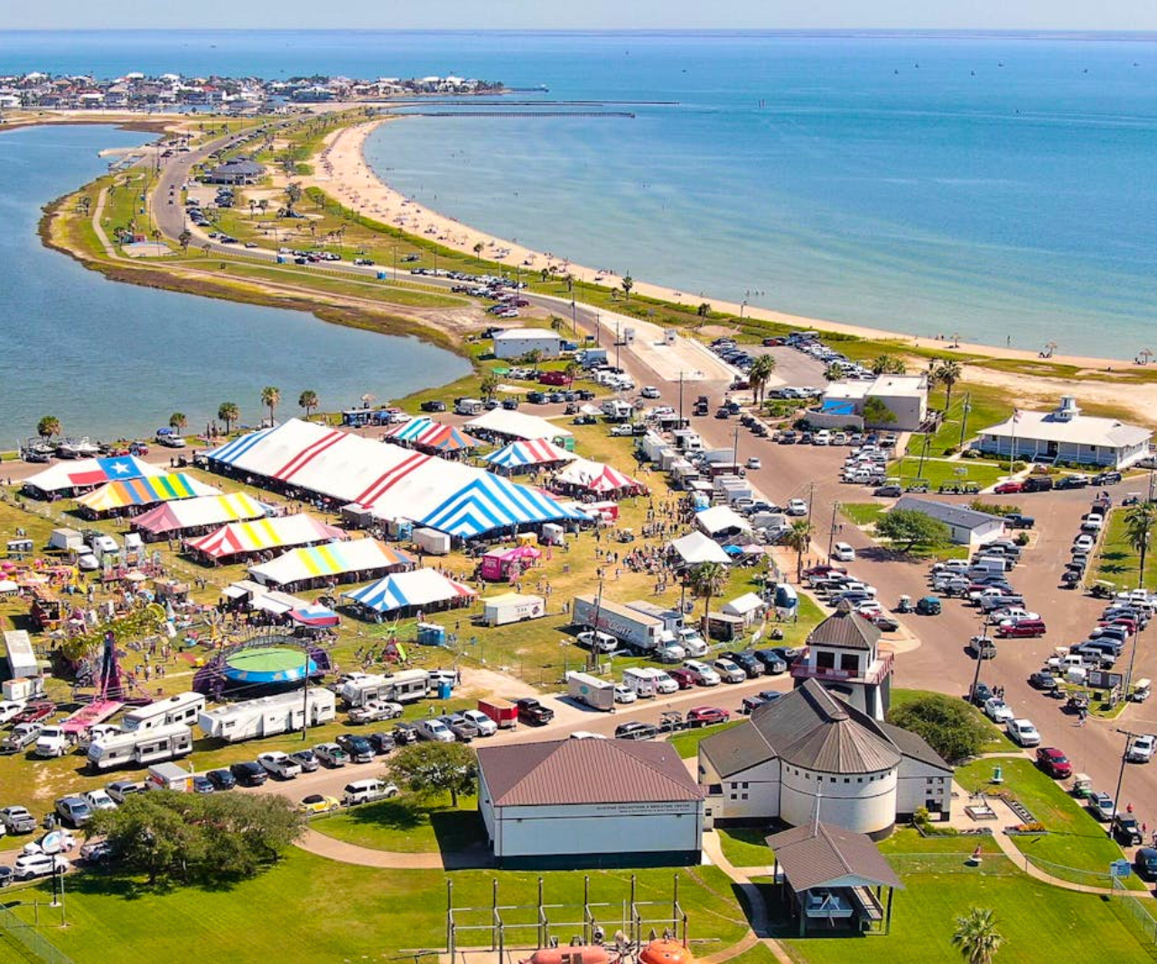 An aerial view of a beach with a lot of tents and cars in Rockport, Texas