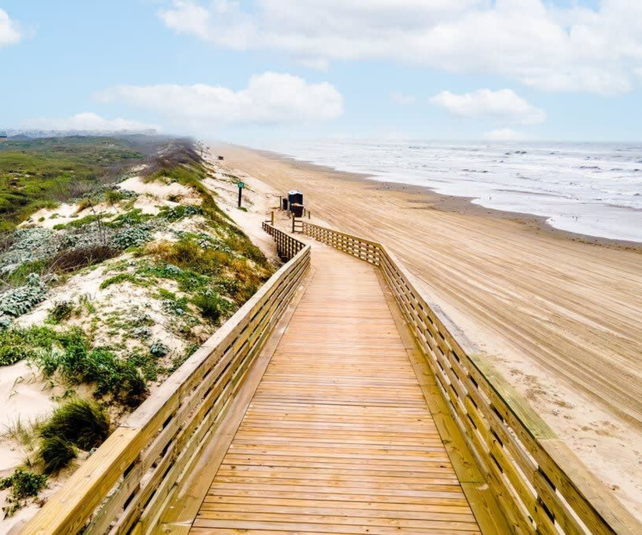 A wooden walkway leading to the beach and ocean in Port Aransas, Texas