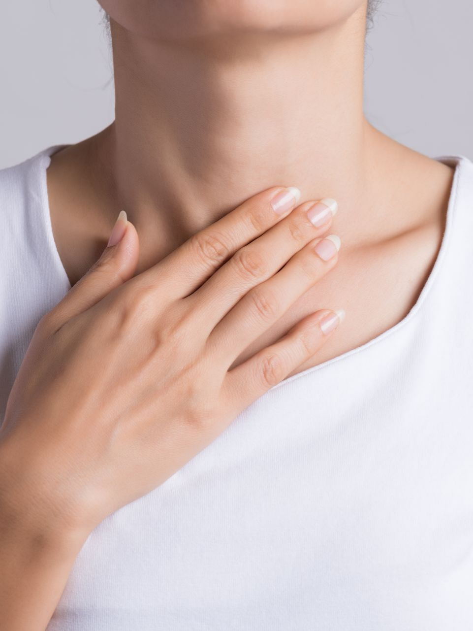 Femme en T-shirt blanc portant la main à son cou