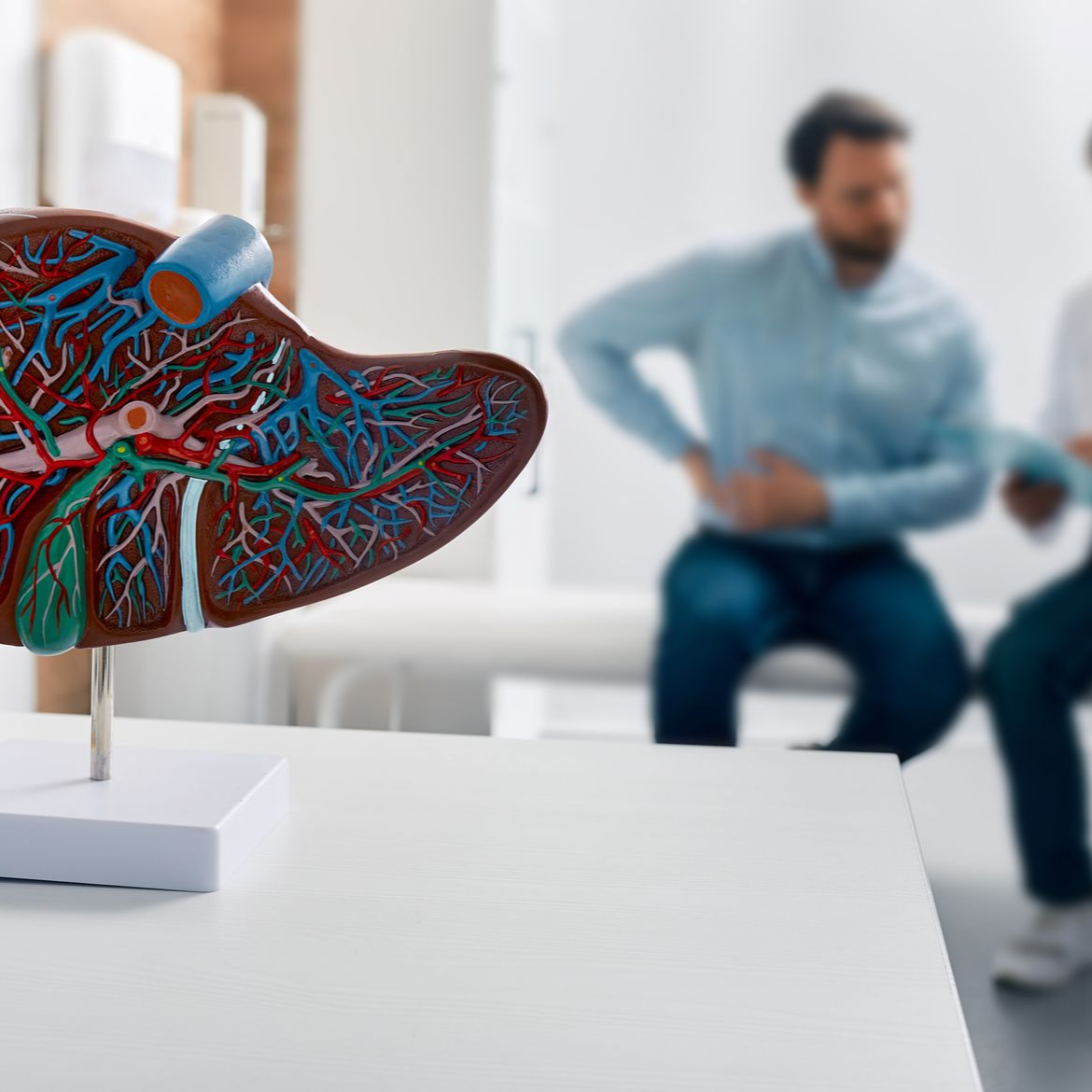 Patient se tenant les côtes avec une coupe de foie anatomique