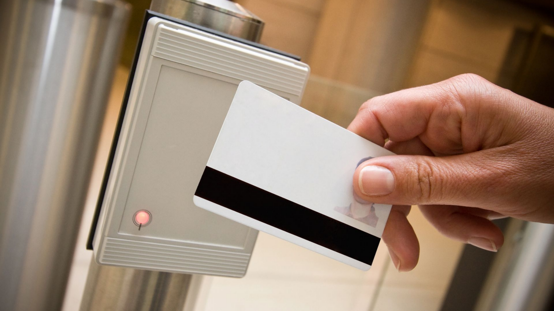 Main tenant un badge près d'un lecteur de cartes de sécurité.