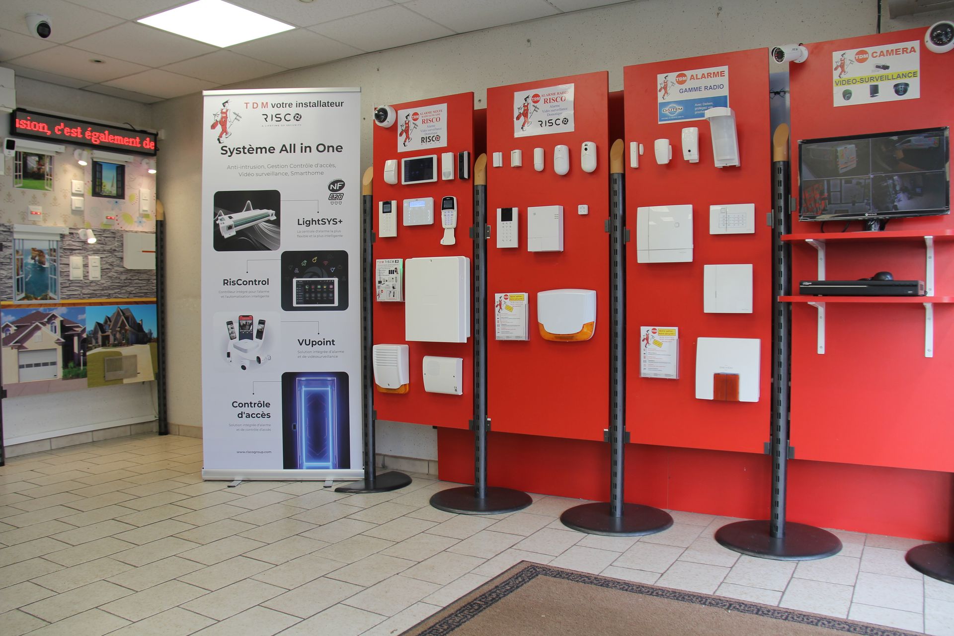Intérieur d'un magasin présentant des appareils de sécurité sur des panneaux rouges.