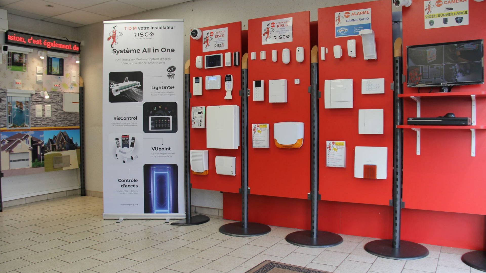Intérieur d'un magasin présentant des appareils de sécurité sur des panneaux rouges.