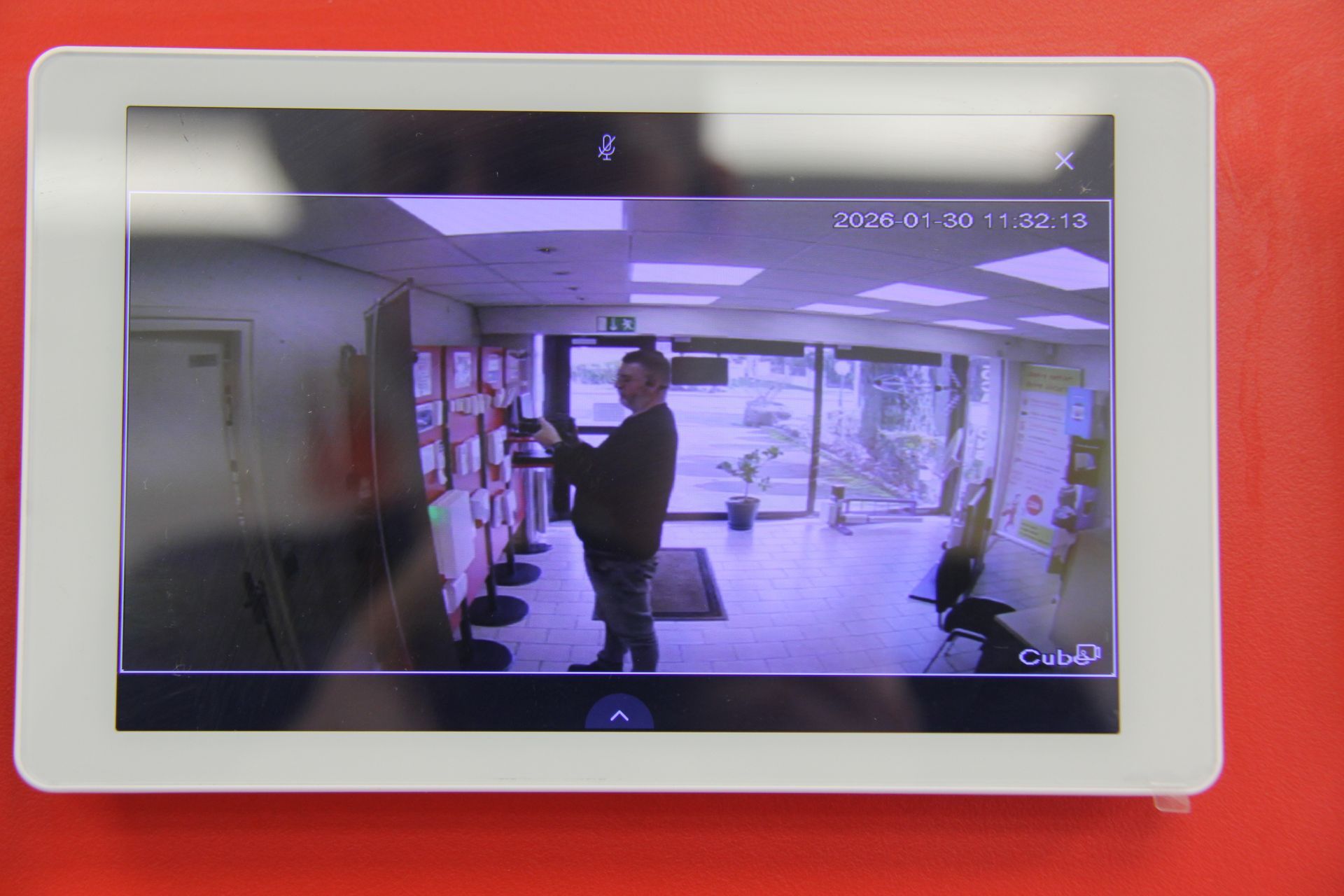 Caméra de vidéosurveillance sur un fond rouge.