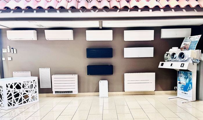 Présentation extérieure d'unités de climatisation et de panneaux muraux sur un mur carrelé de salle d'exposition