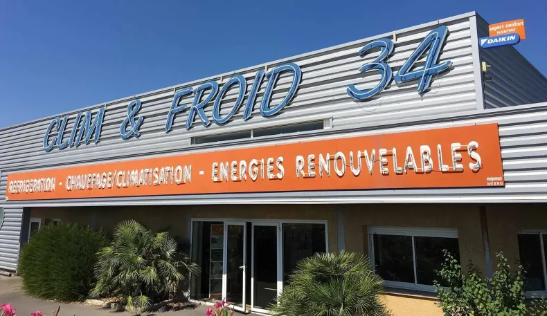 Façade de magasin avec enseigne Froid 34 et banderole orange indiquant 