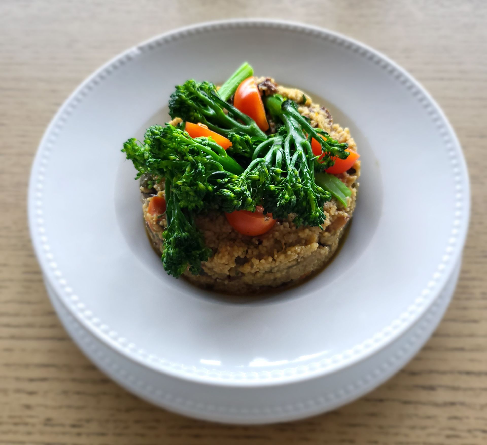 Um prato branco coberto com um ovo frito e espinafre