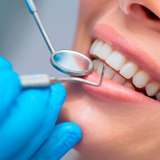 Una mujer está siendo examinada por un dentista.