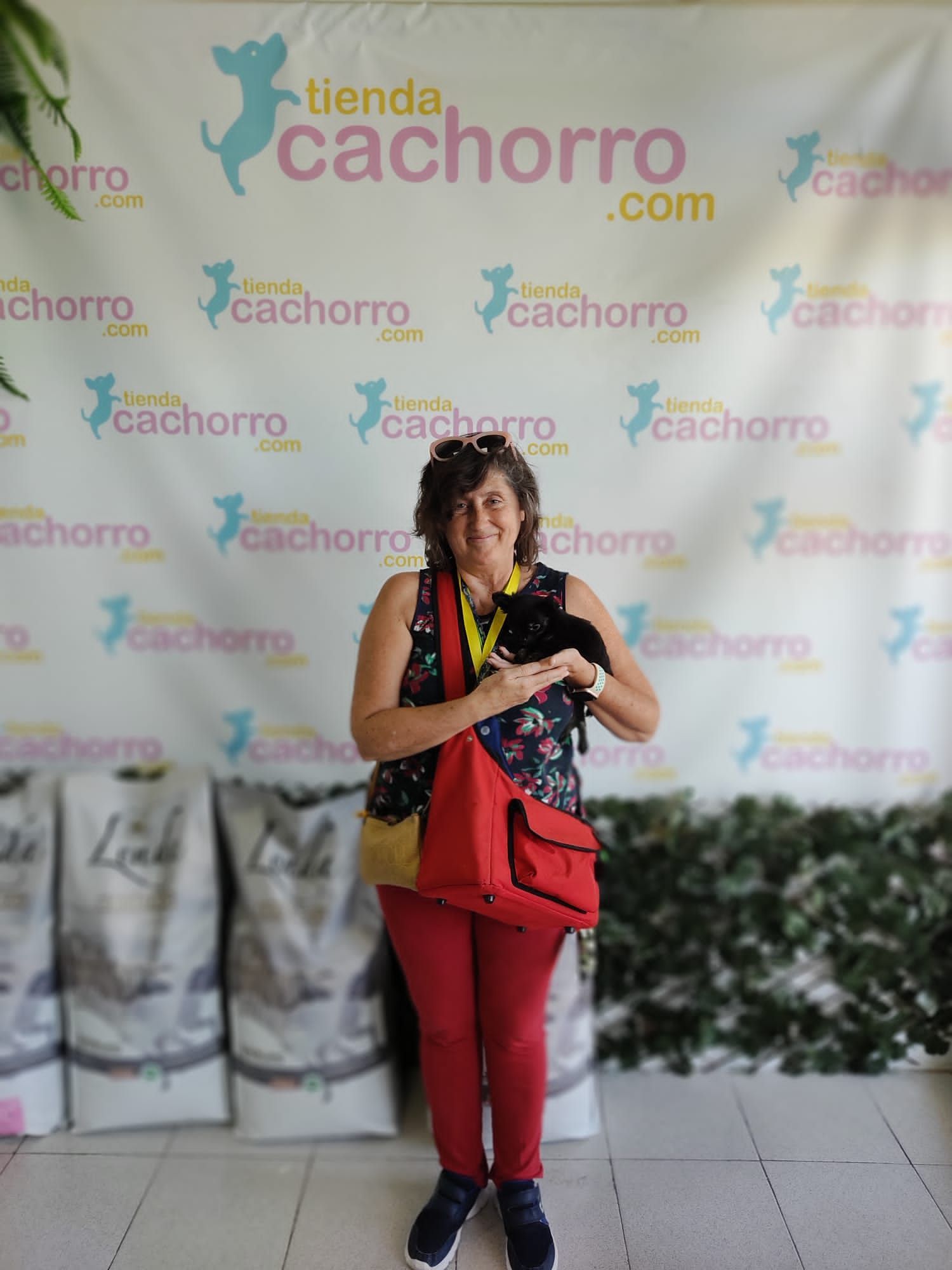 Una mujer está parada frente a una pared que dice tienda cachorro