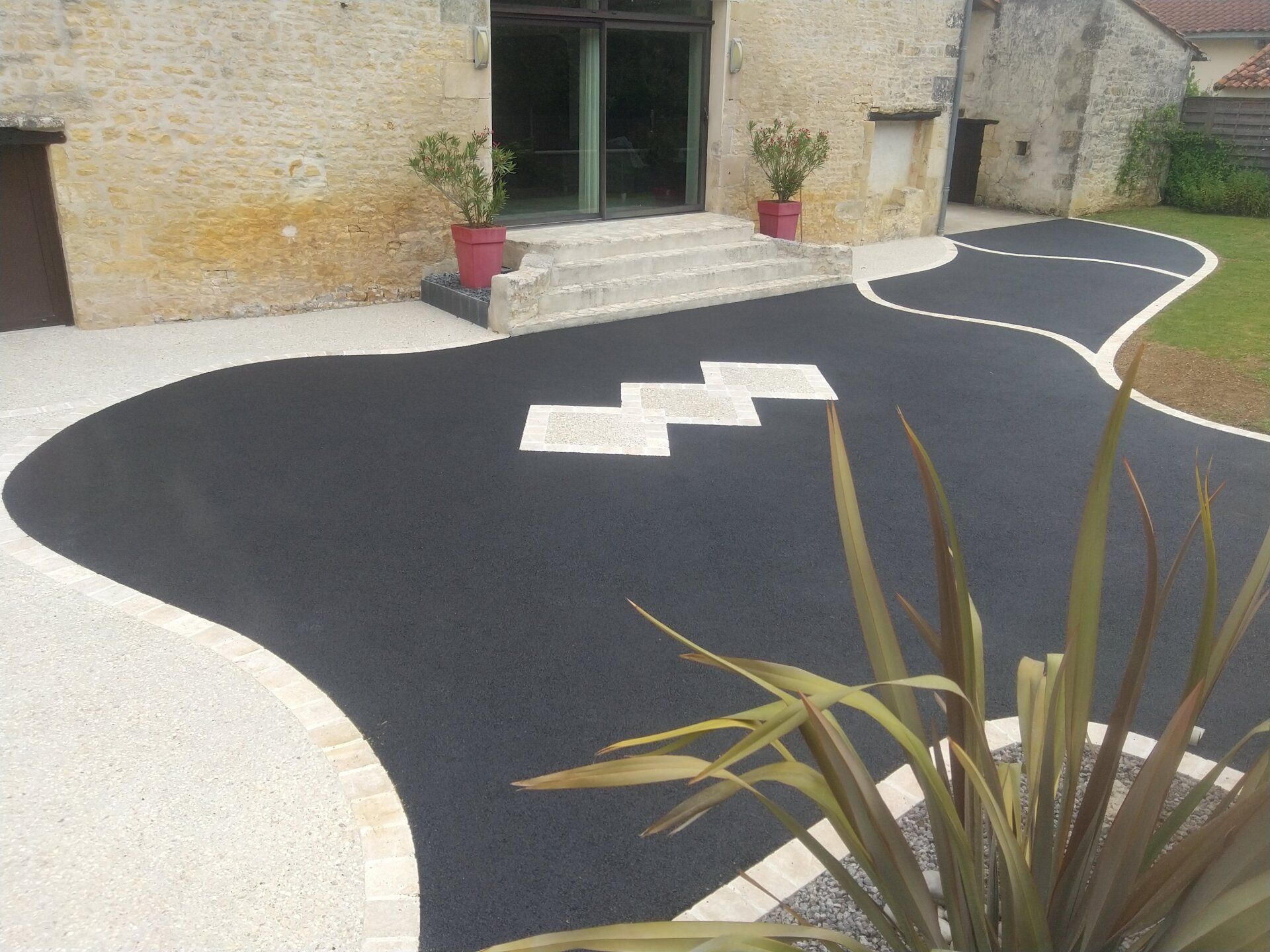 Allée d'une maison en goudron avec des losanges