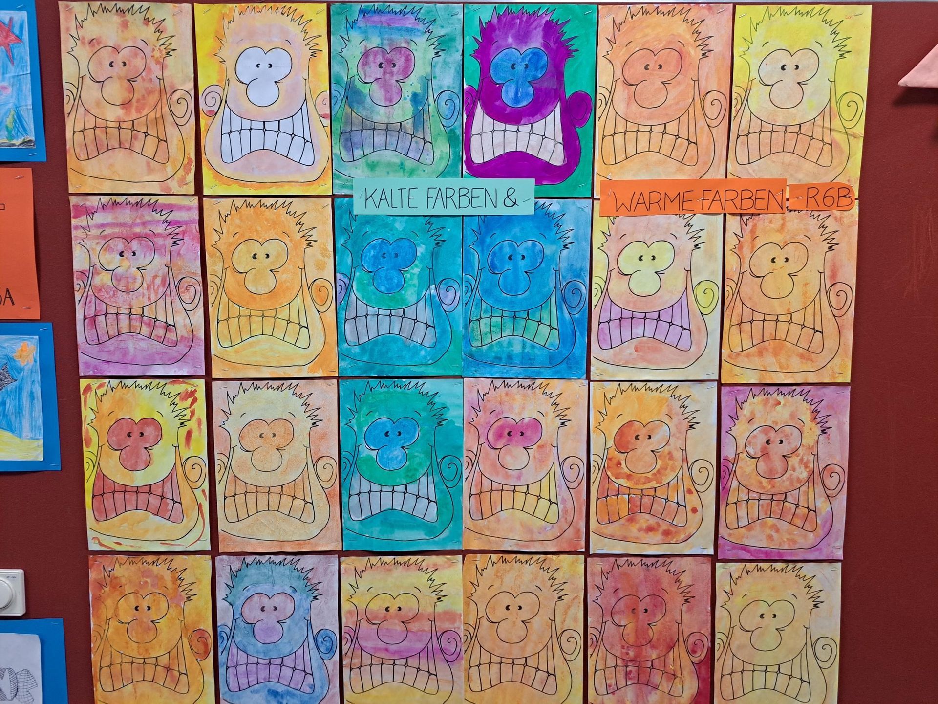 Eine Wandausstellung mit Affenzeichnungen in verschiedenen Farben mit schwarzen Umrissen.