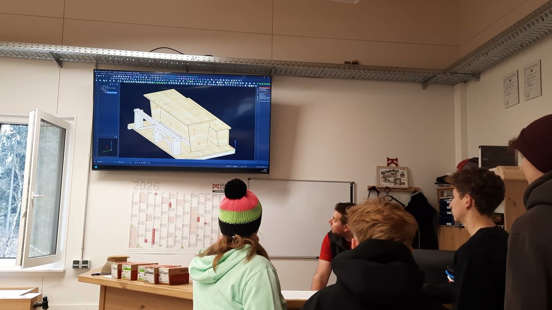 Students look at a 3D building design displayed on a classroom screen.
