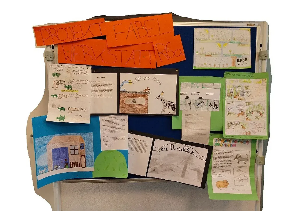 Schwarzes Brett mit Kinderzeichnungen und handgeschriebenen Notizen, gestaltet mit Zeichnungen und buntem Papier.