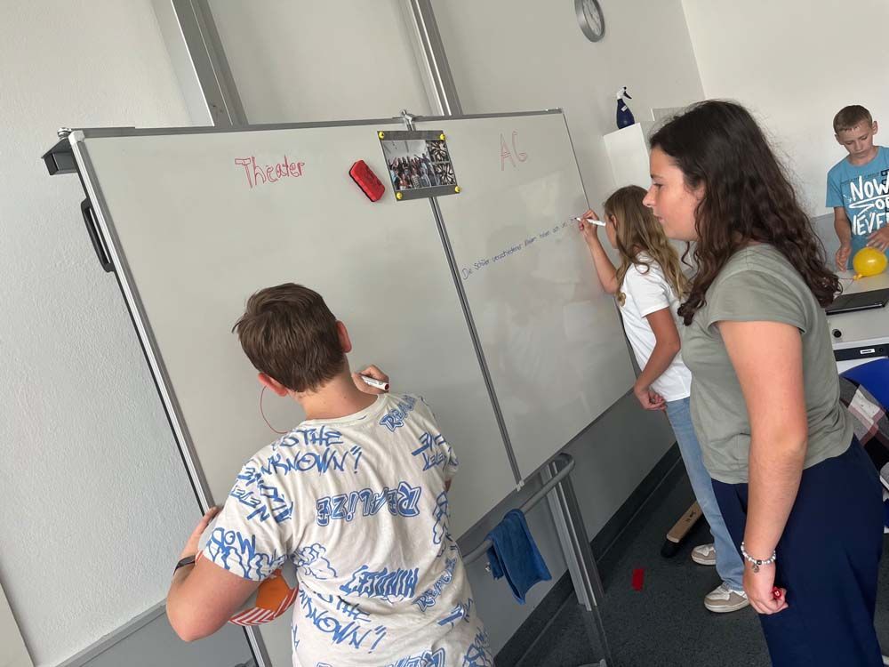 Schüler schreiben auf einer Tafel in einem Klassenzimmer.