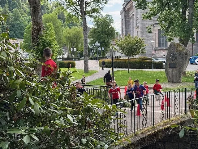 Menschen rennen über eine Brücke vor einer Kirche, rote Markierungen.