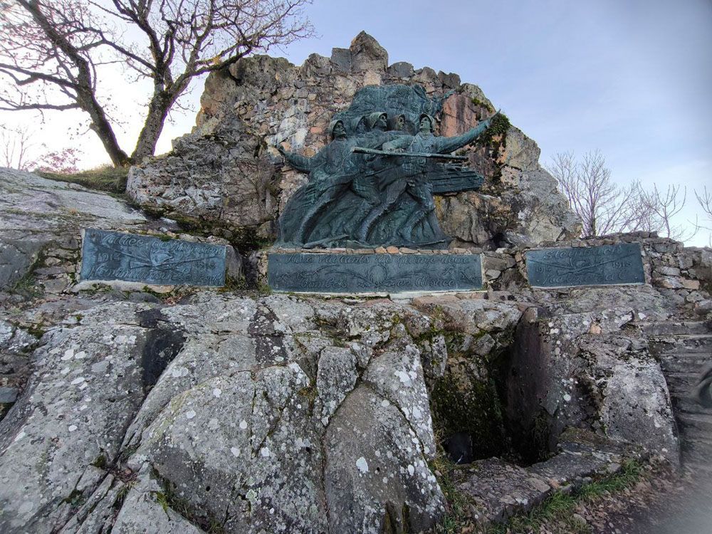 Bronzeskulptur auf einem Felsenhügel. Enthält drei Gedenktafeln.