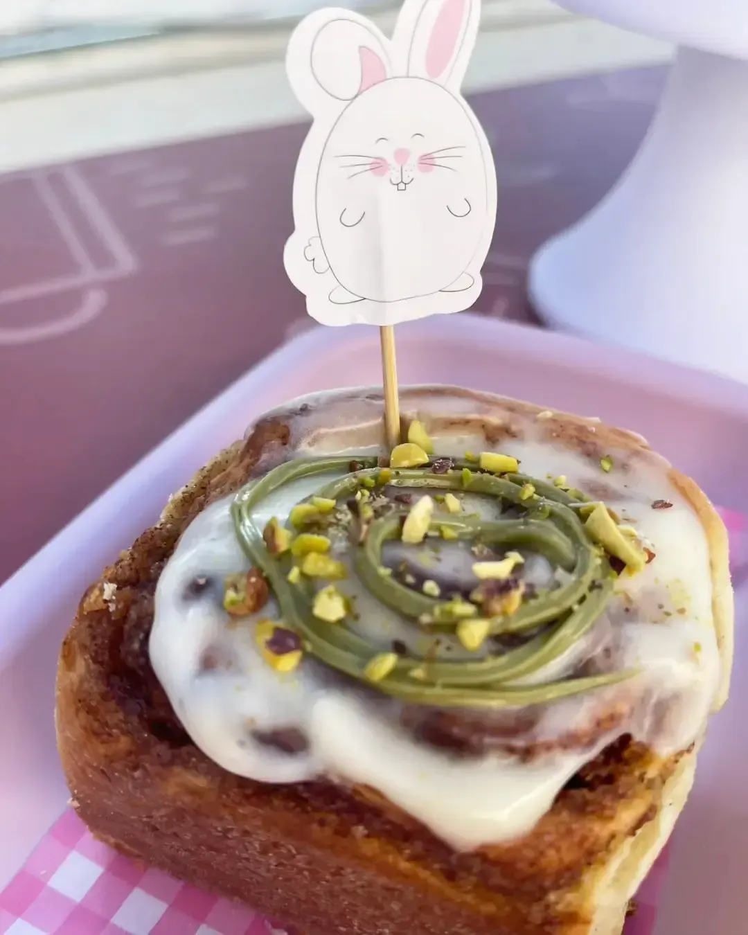 Un plato negro cubierto con patatas y salsa sobre una mesa de madera.