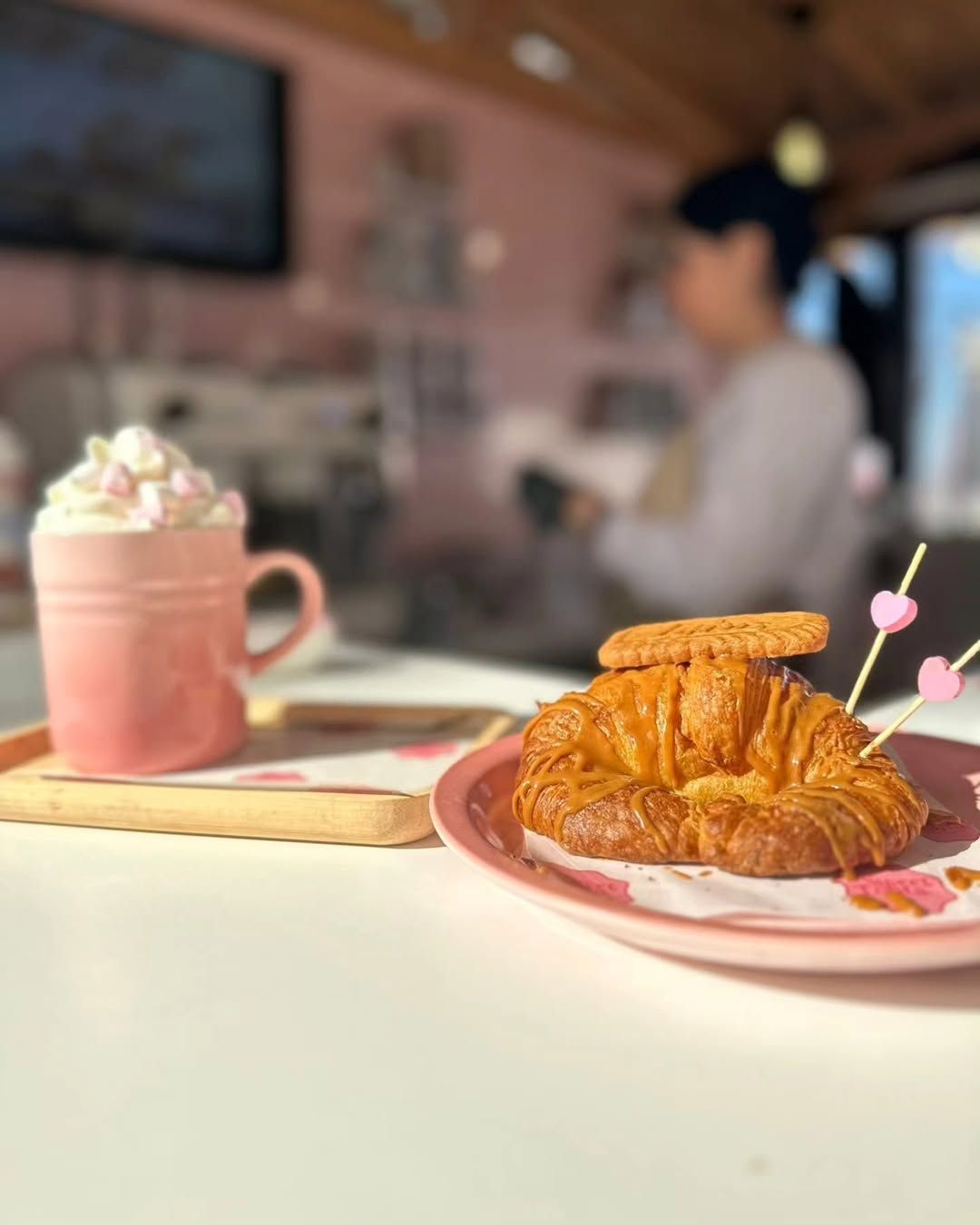 Un plato negro cubierto con patatas y salsa sobre una mesa de madera.
