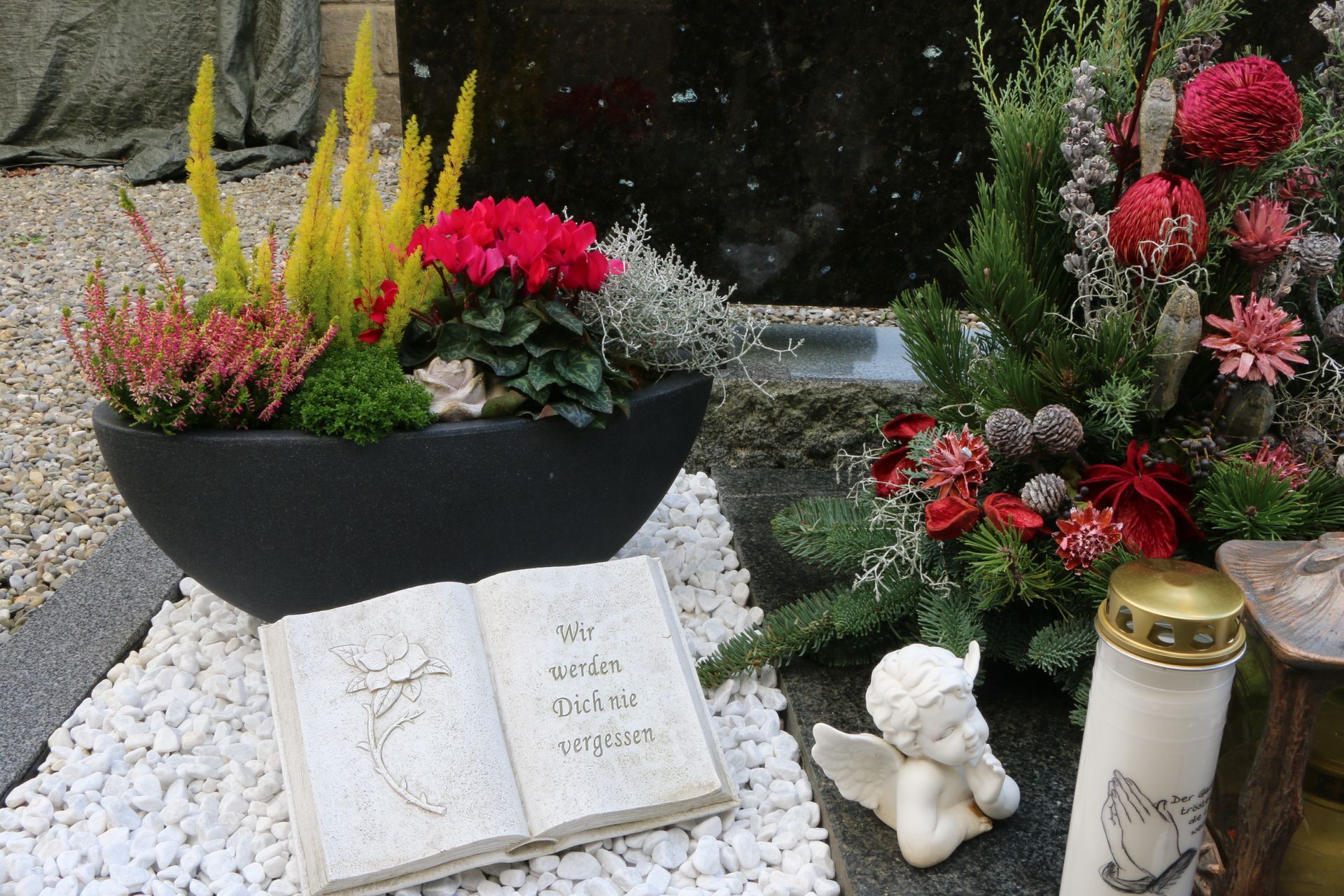 ein Grab mit Blumen und einem Buch darauf