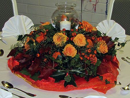 ein Tisch mit einer Blumenvase und einer Kerze darauf