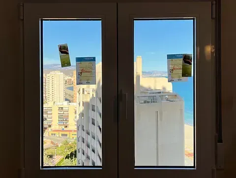 Una ventana con vista a una ciudad y al océano.