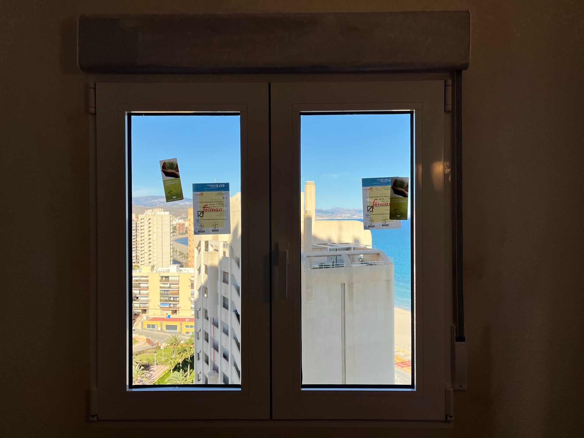Una ventana con vista a una ciudad y al océano.