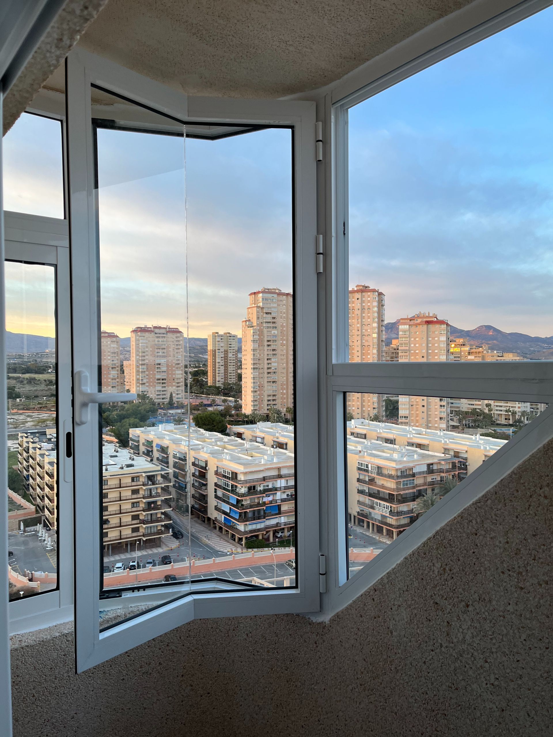 Una vista de una ciudad a través de una ventana abierta