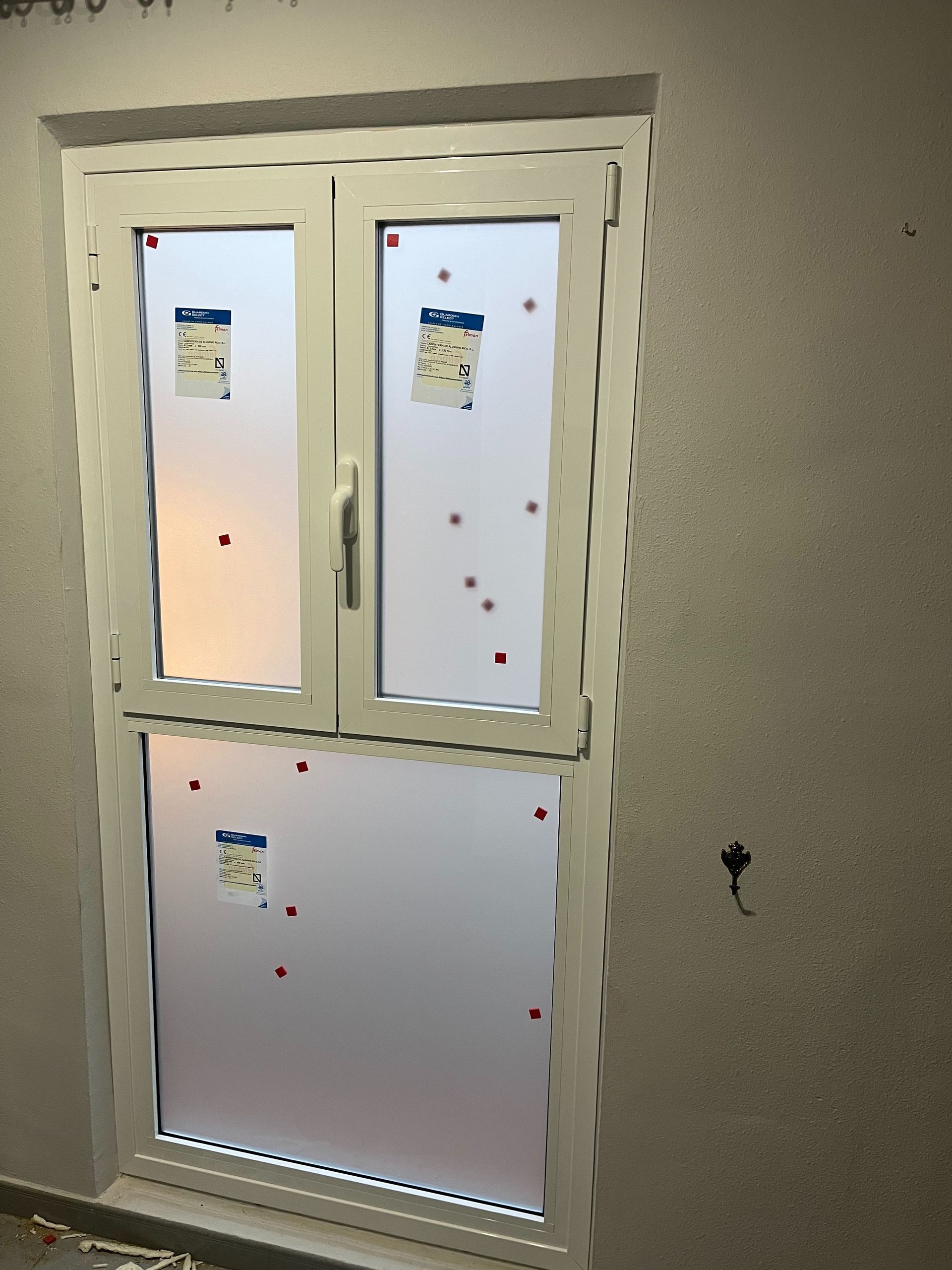 Se está instalando una puerta blanca con pegatinas.