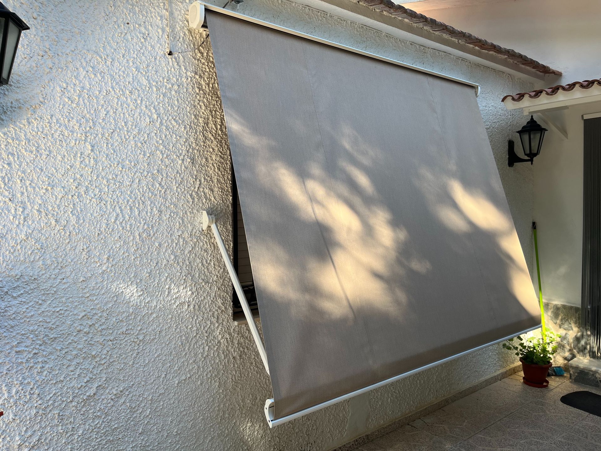 Una ventana con un toldo gris.