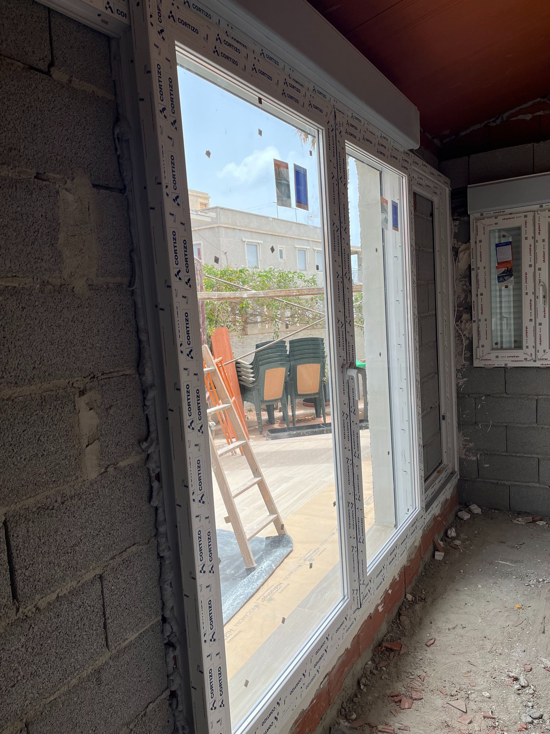 Una habitación con muchas ventanas y una escalera en ella.