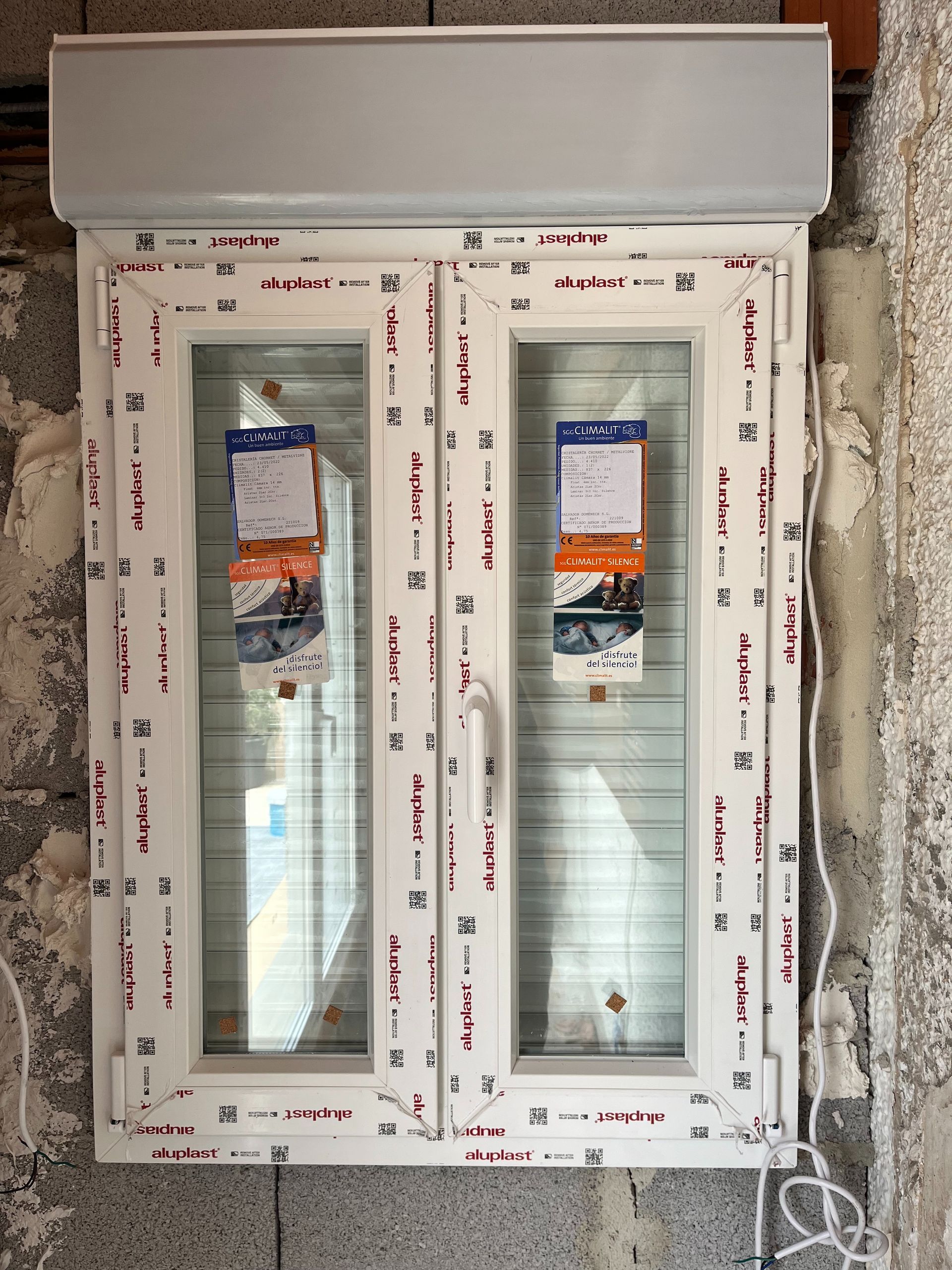 Una ventana de plástico blanca con una persiana.