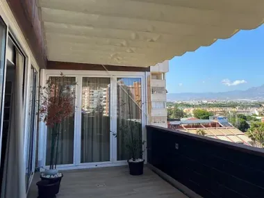 Un balcón con marquesina y vista a la ciudad.