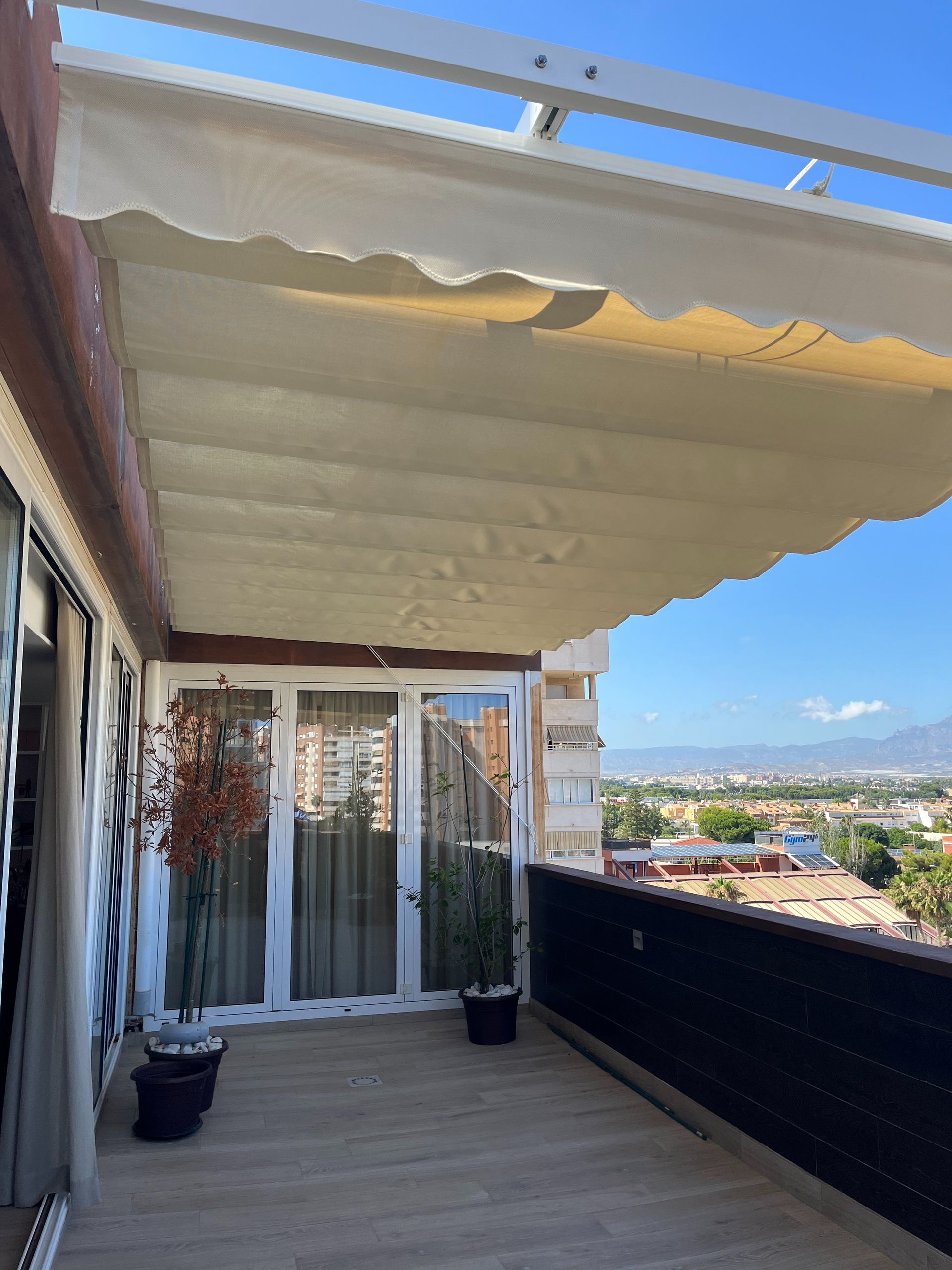 Un balcón con marquesina y vista a la ciudad.