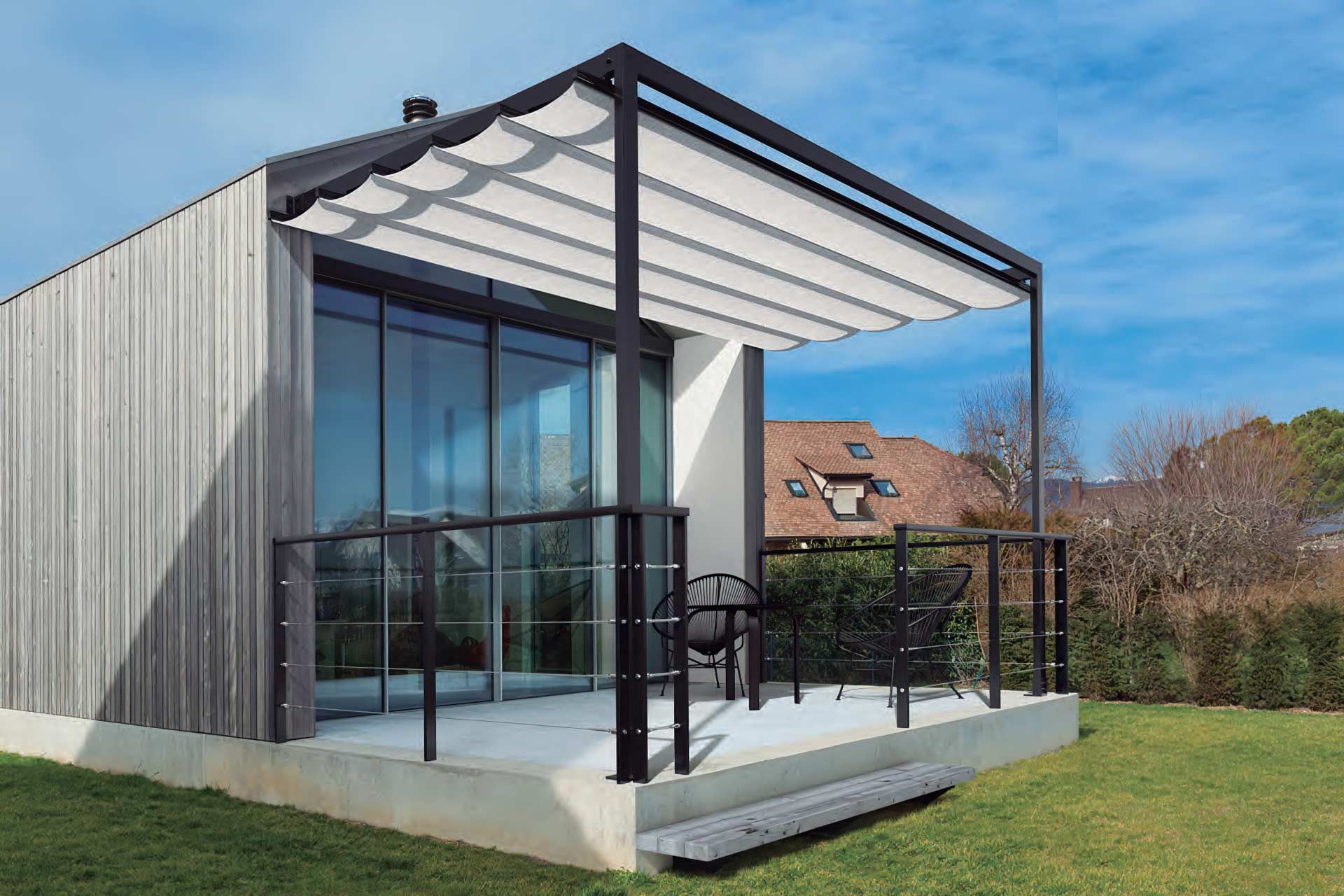 Una pequeña casa con una pérgola en el costado.