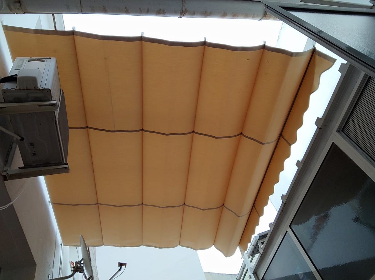 Un toldo color canela cuelga del techo de un edificio.