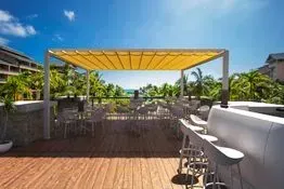 Un patio con mesas y sillas bajo un dosel.