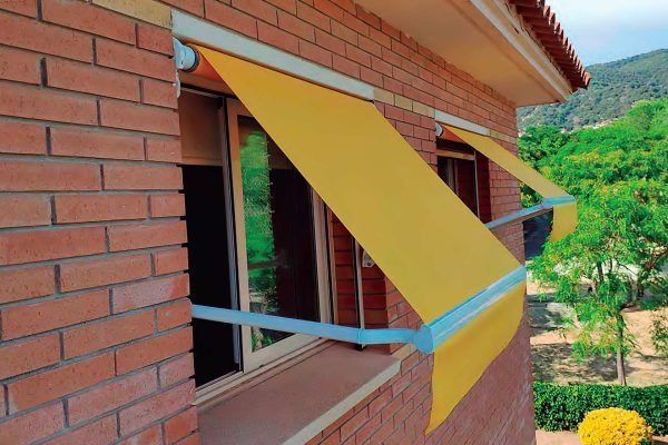 Un edificio de ladrillo con un toldo amarillo sobre una ventana.