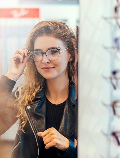 Una mujer se está probando gafas en una óptica.