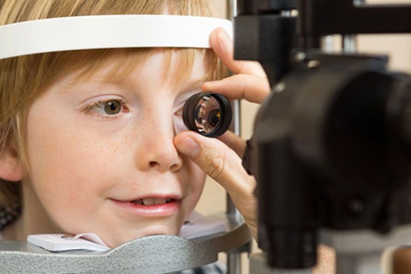 Un niño pequeño está siendo examinado por un oftalmólogo.