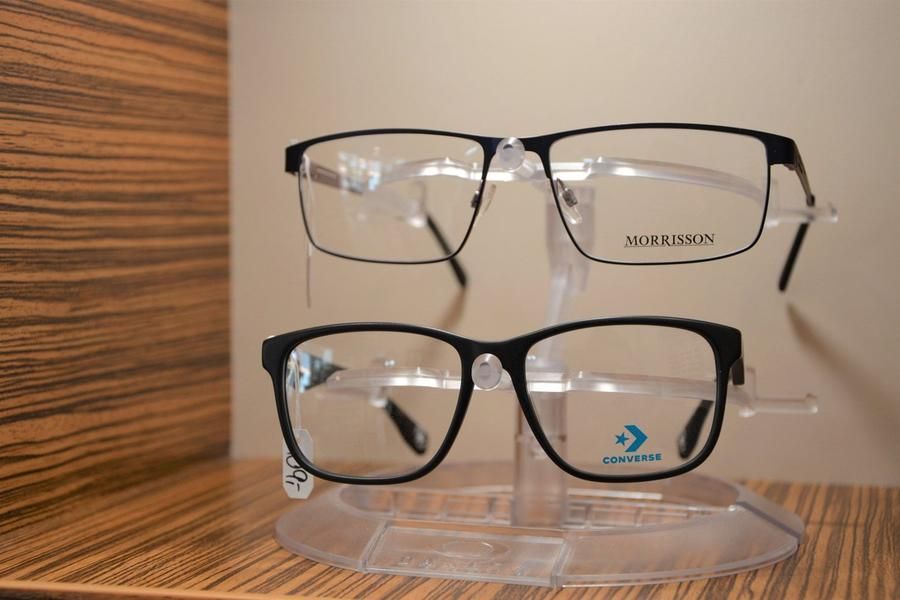 Zwei Brillen liegen übereinander auf einem Präsentationsständer.